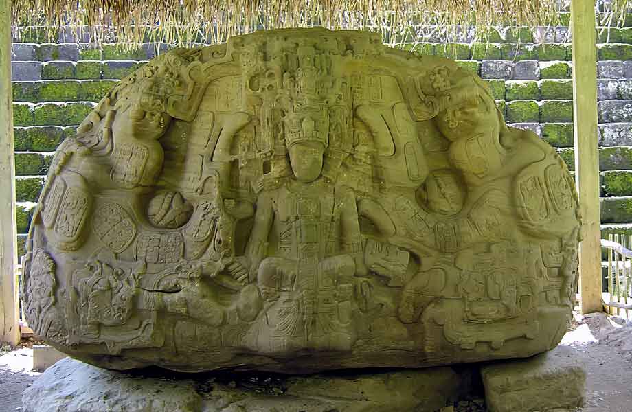 An ornately carved stone altar at Quirigua, displaying intricate Mayan motifs and glyphs that narrate stories of ceremonies and rituals from ancient times.