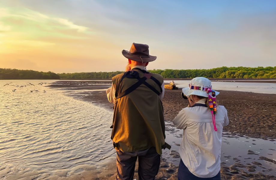 Couple immersed in birdwatching bliss along the Pacific coast of Guatemala, capturing the beauty of local avian species.