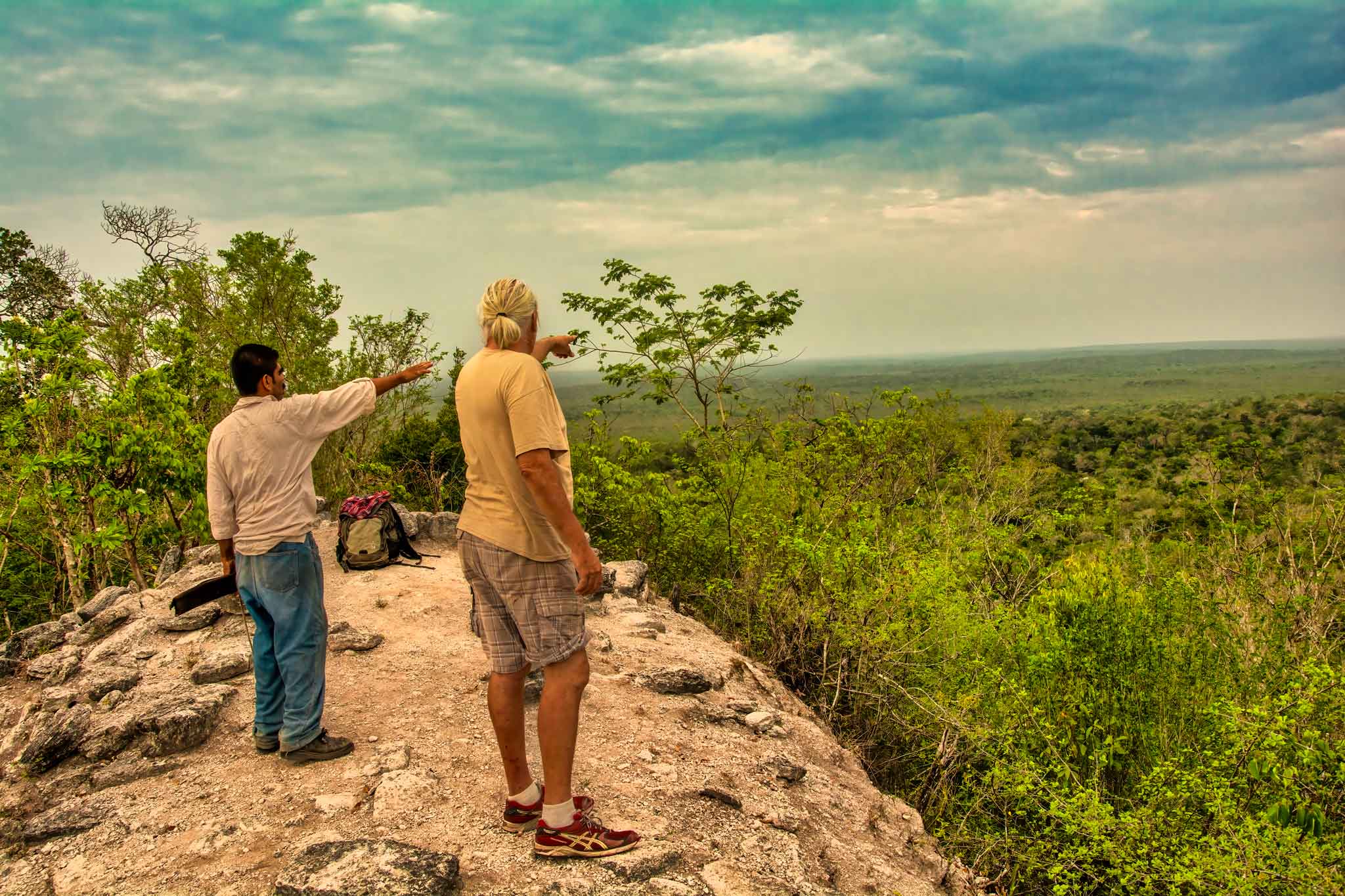 Adventure travelers on top of the Mayan World, during El Mirador HIking trail, Guatemala.