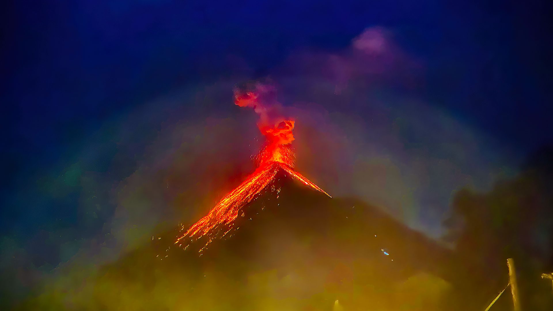 Acatenango Volcano Tour - Nocturnal view of Fuego Volcano erupting, seen from Acatenango Volcano, showcasing spectacular bursts of radiant magma, during the Volcano Hiking Trail in Guatemala.